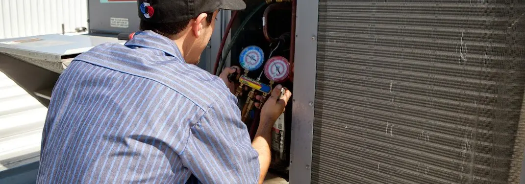 HVAC technician servicing a condenser unit in Hidden Valley Lake